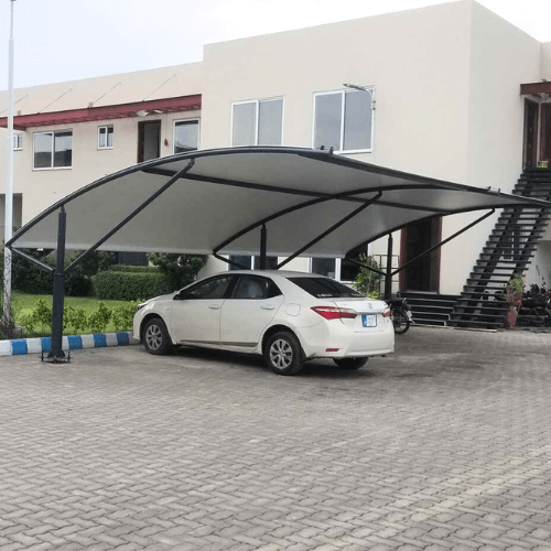 Car parking shed with tensile fabric, protecting vehicles from sun, rain, and harsh weather conditions.