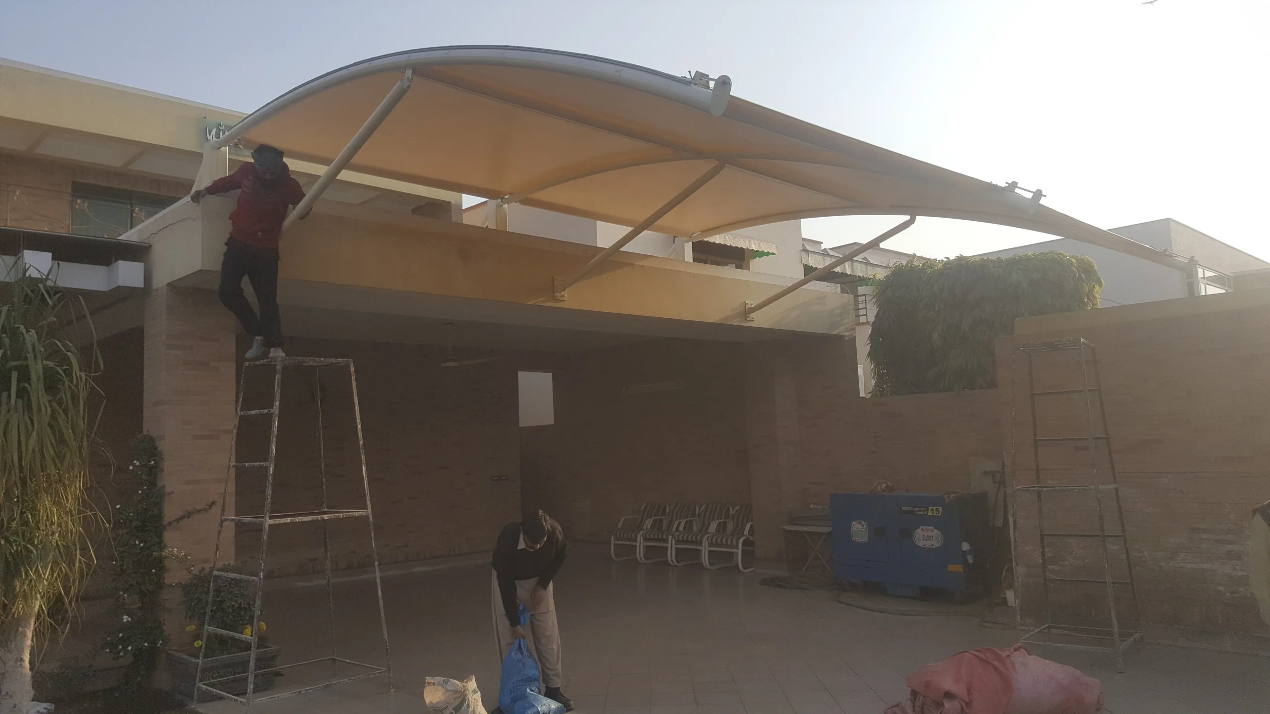 Home Front Wall Mounted shed (1) Home front wall-mounted shed with durable tensile fabric, offering enhanced shading and protection from the sun and rain.