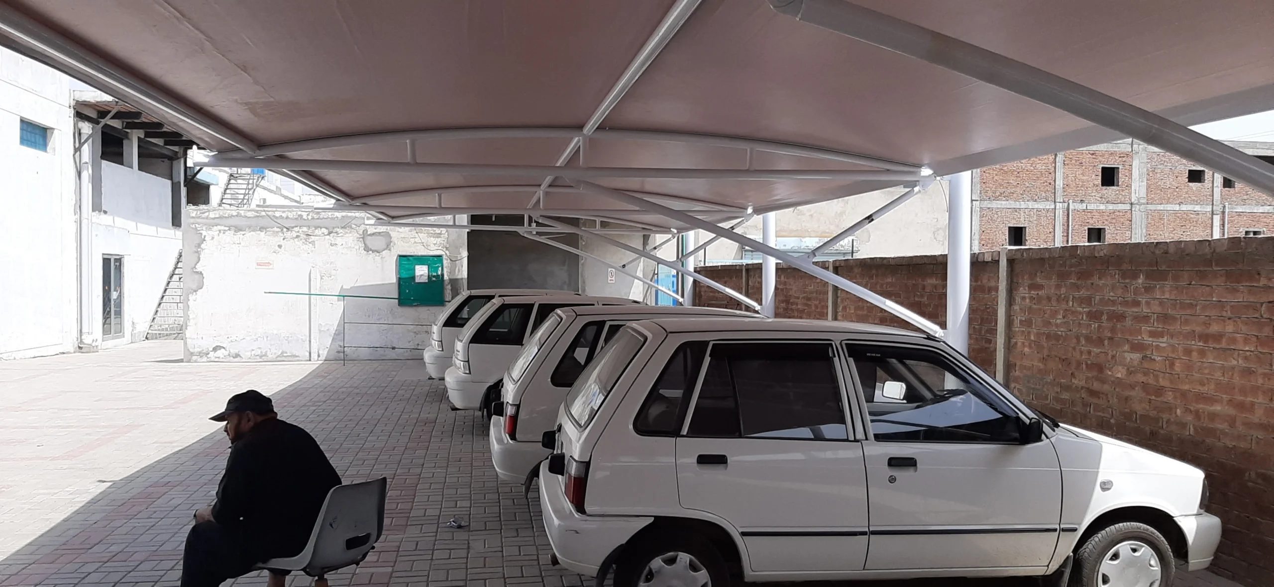 Tensile fabric car parking shades provide durable, weather-resistant protection for vehicles, designed for both residential and commercial use, tailored to the weather conditions of Pakistan.