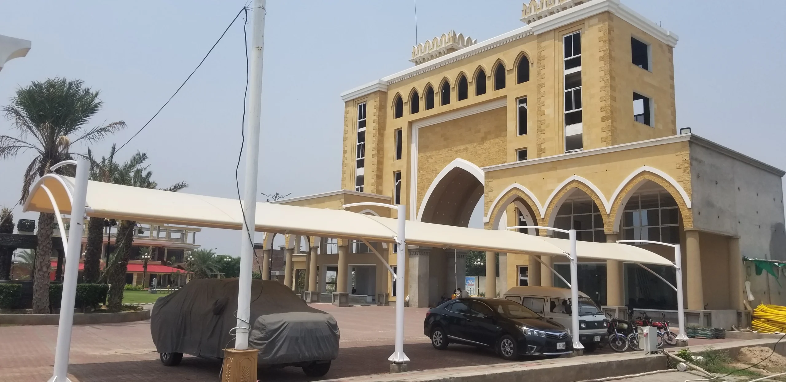 Durable tensile fabric outdoor car parking shade for effective sun and weather protection, ideal for homes and commercial spaces.