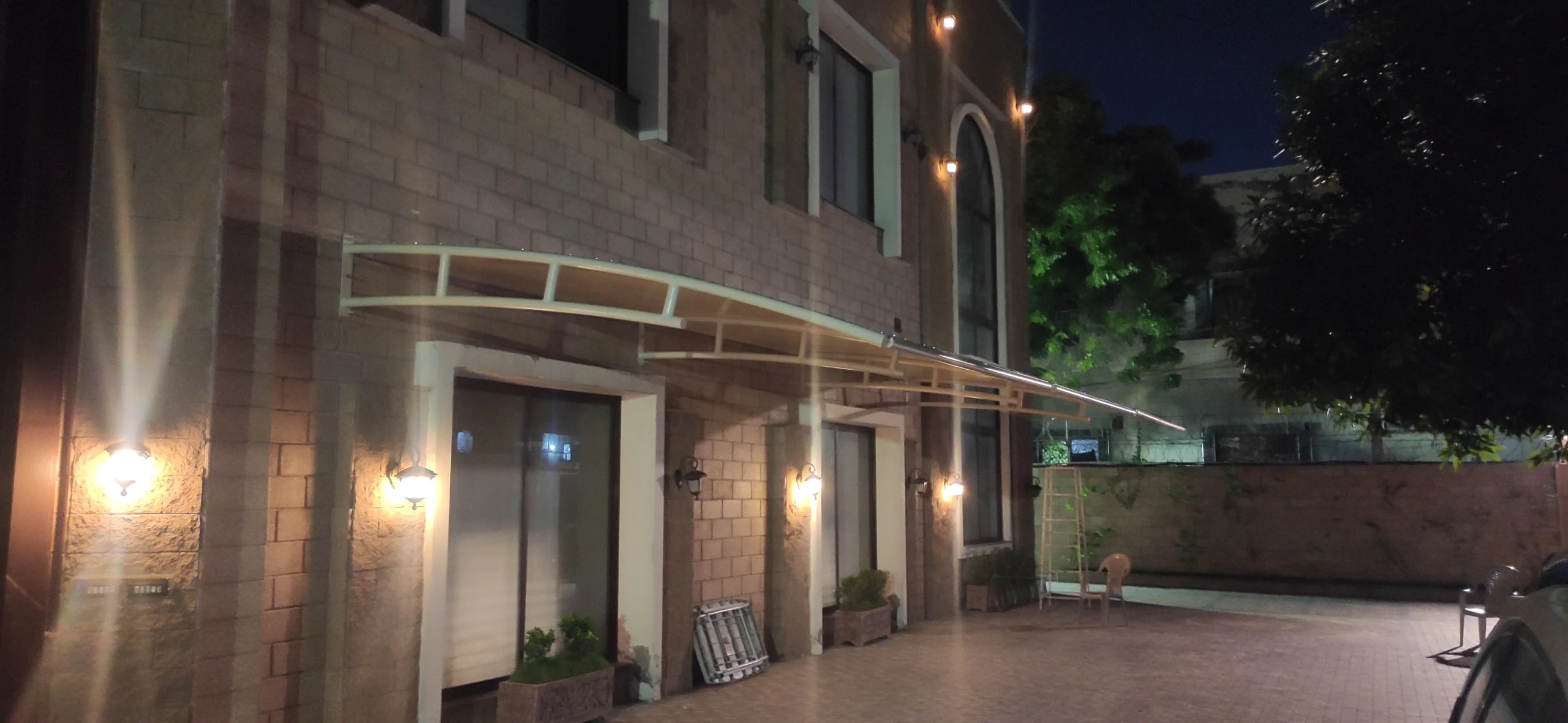 Dual-Purpose Patio Cover and Car Parking Shade (2) Dual-purpose patio cover and car parking shade featuring tensile fabric protection with a sleek wall-mounted design, combining functionality and style for outdoor spaces.