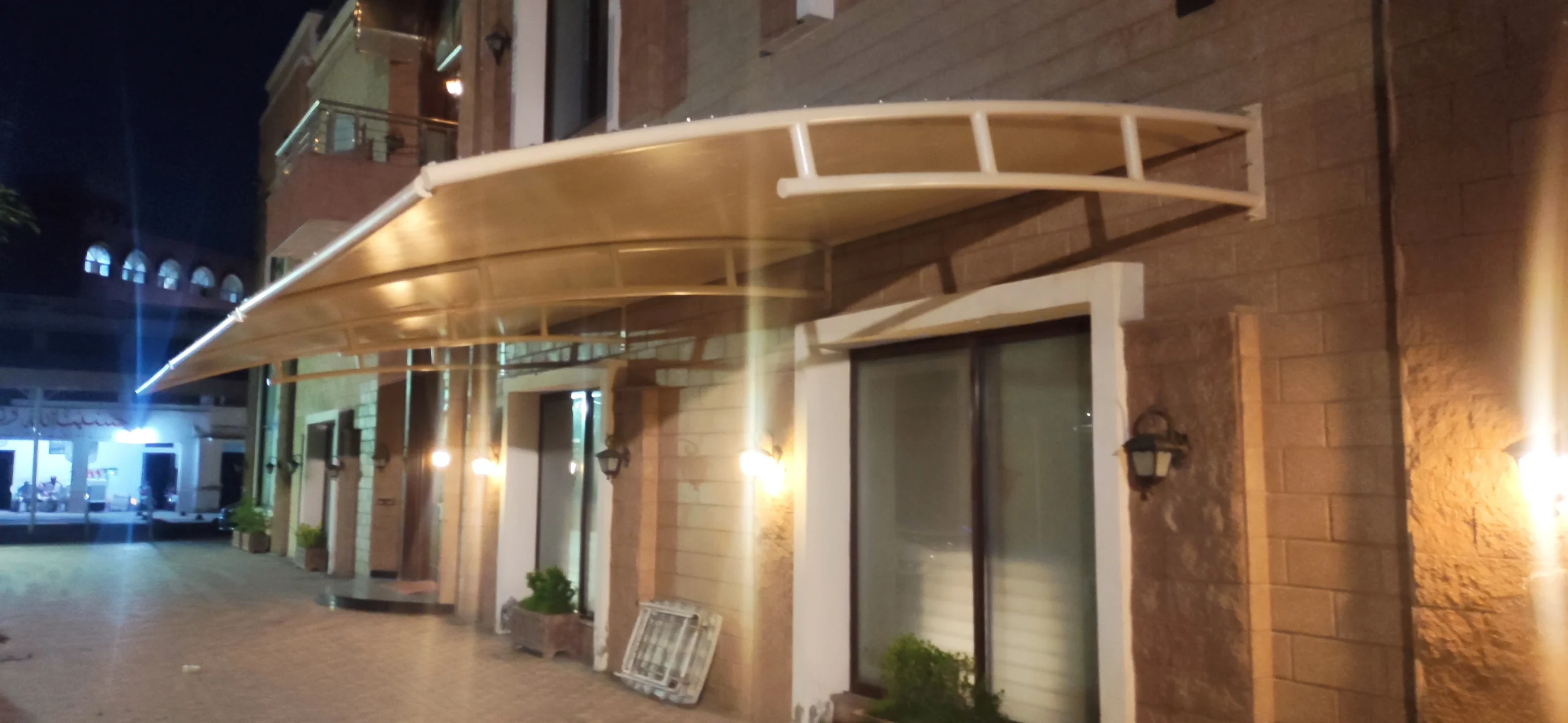 Dual-Purpose Patio Cover and Car Parking Shade (3) Dual-purpose patio cover and car parking shade featuring tensile fabric protection with a sleek wall-mounted design, combining functionality and style for outdoor spaces.