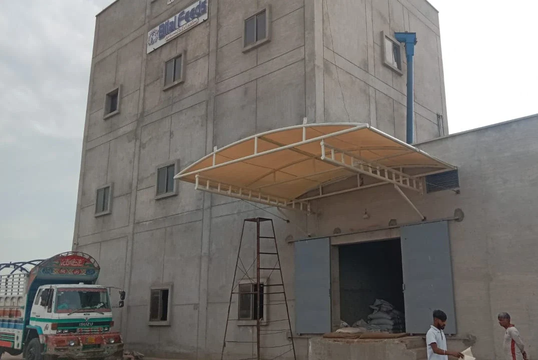 Premium Warehouse Delivery Gate Shade (2) Premium warehouse delivery gate shade made of durable tensile fabric with a wall-mounted design, providing weather-resistant coverage for commercial loading zones.